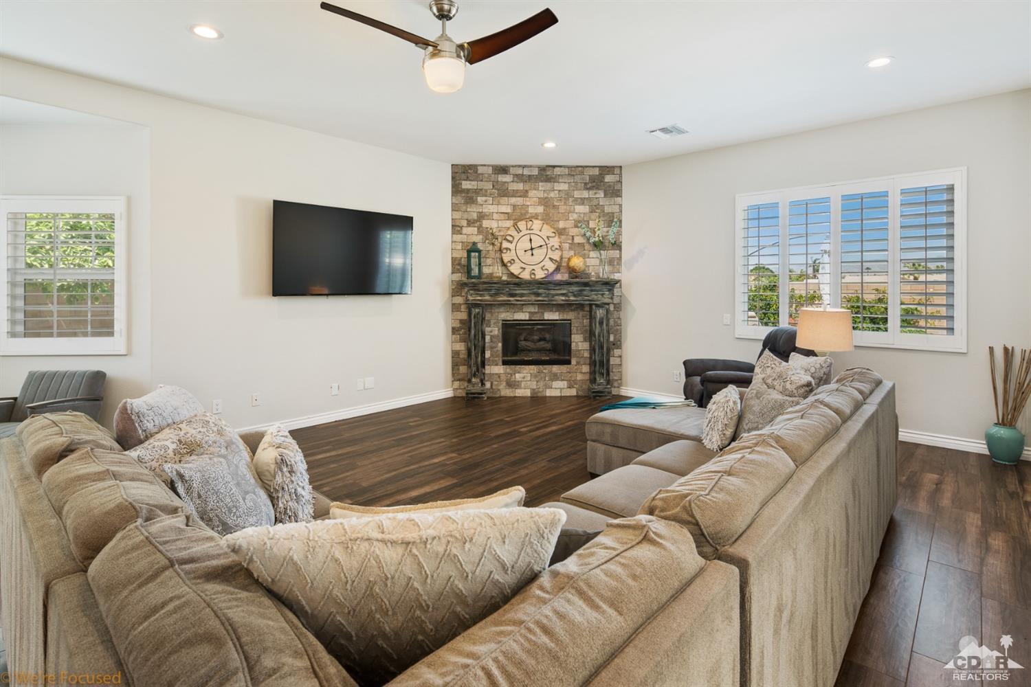 14 Tucson Circle Palm Desert, CA 92211 - Photo 8 of 20 a living room with furniture a flat screen tv and a fireplace