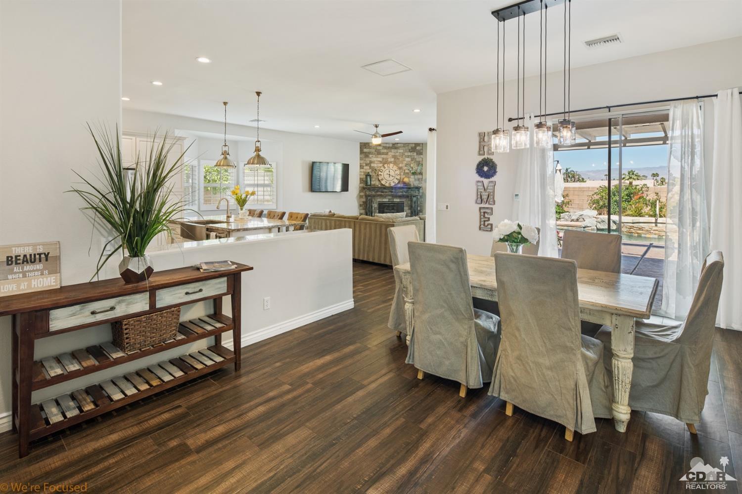 14 Tucson Circle Palm Desert, CA 92211 - Photo 9 of 20 a dining room with furniture a chandelier and wooden floor
