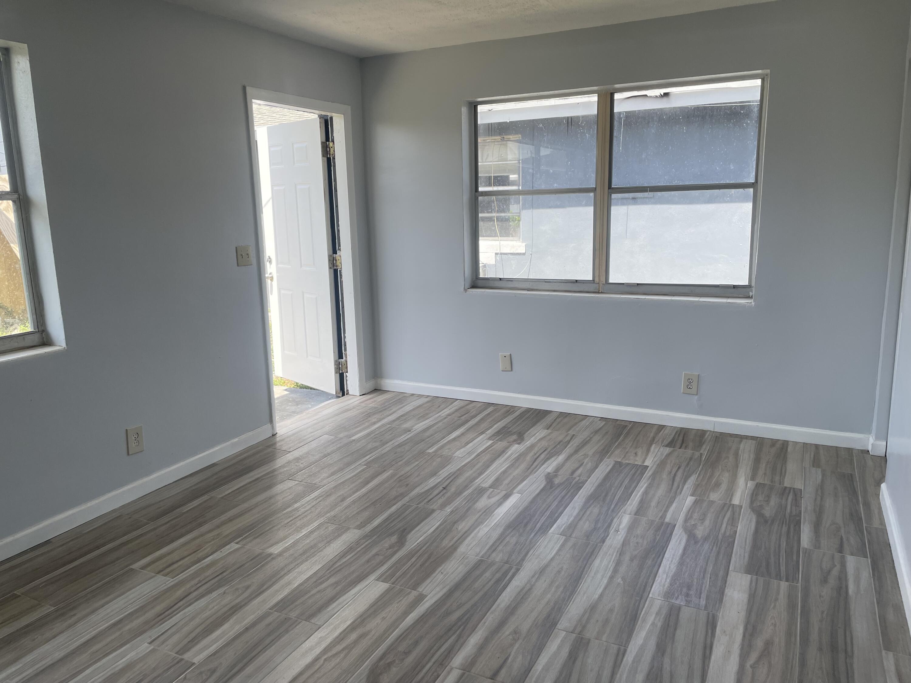 111 East 27th Street, Unit 113B Riviera Beach, FL 33404 - Photo 1 of 5 an empty room with wooden floor and windows