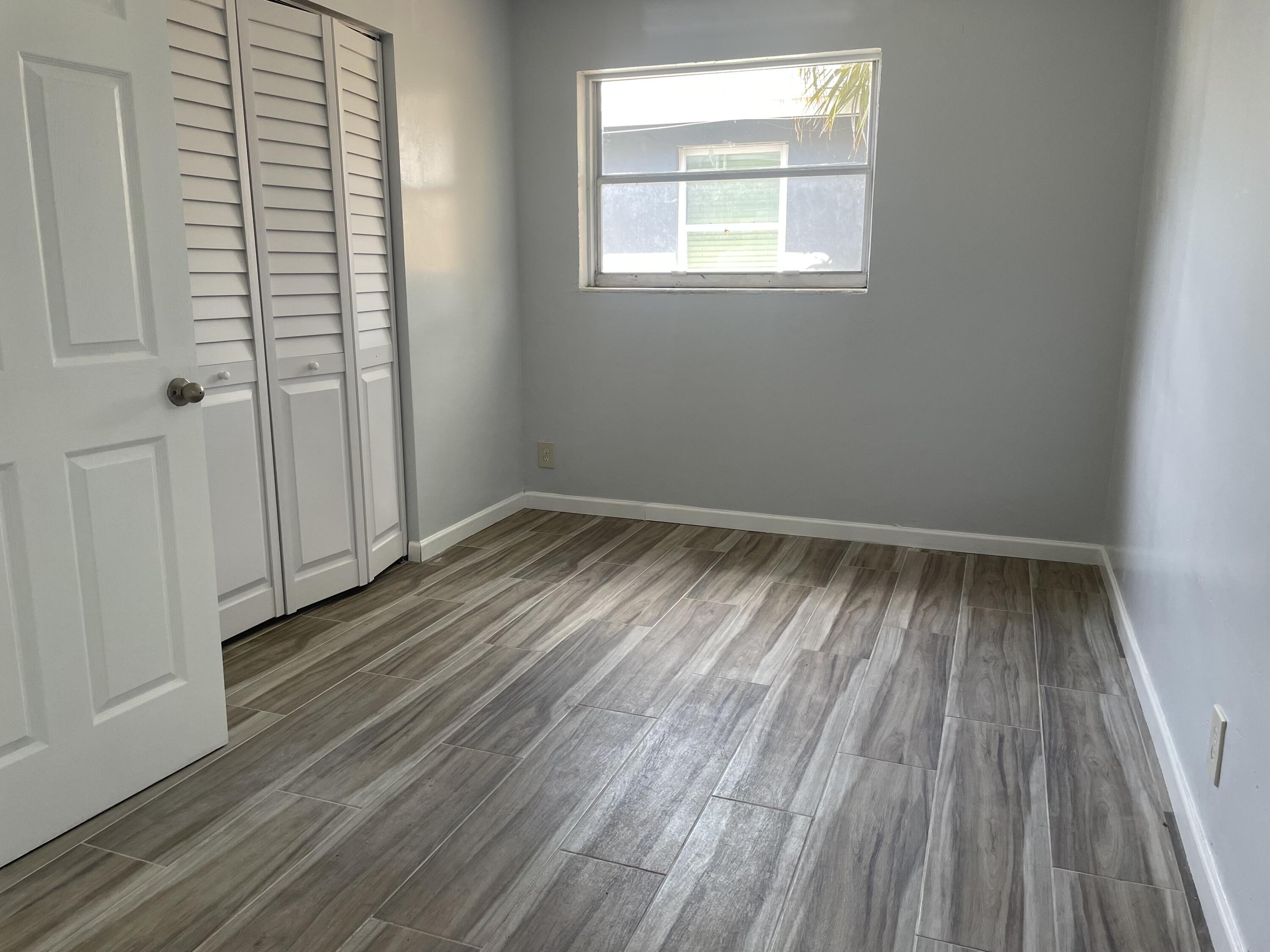 111 East 27th Street, Unit 113B Riviera Beach, FL 33404 - Photo 4 of 5 wooden floor in an empty room with a window