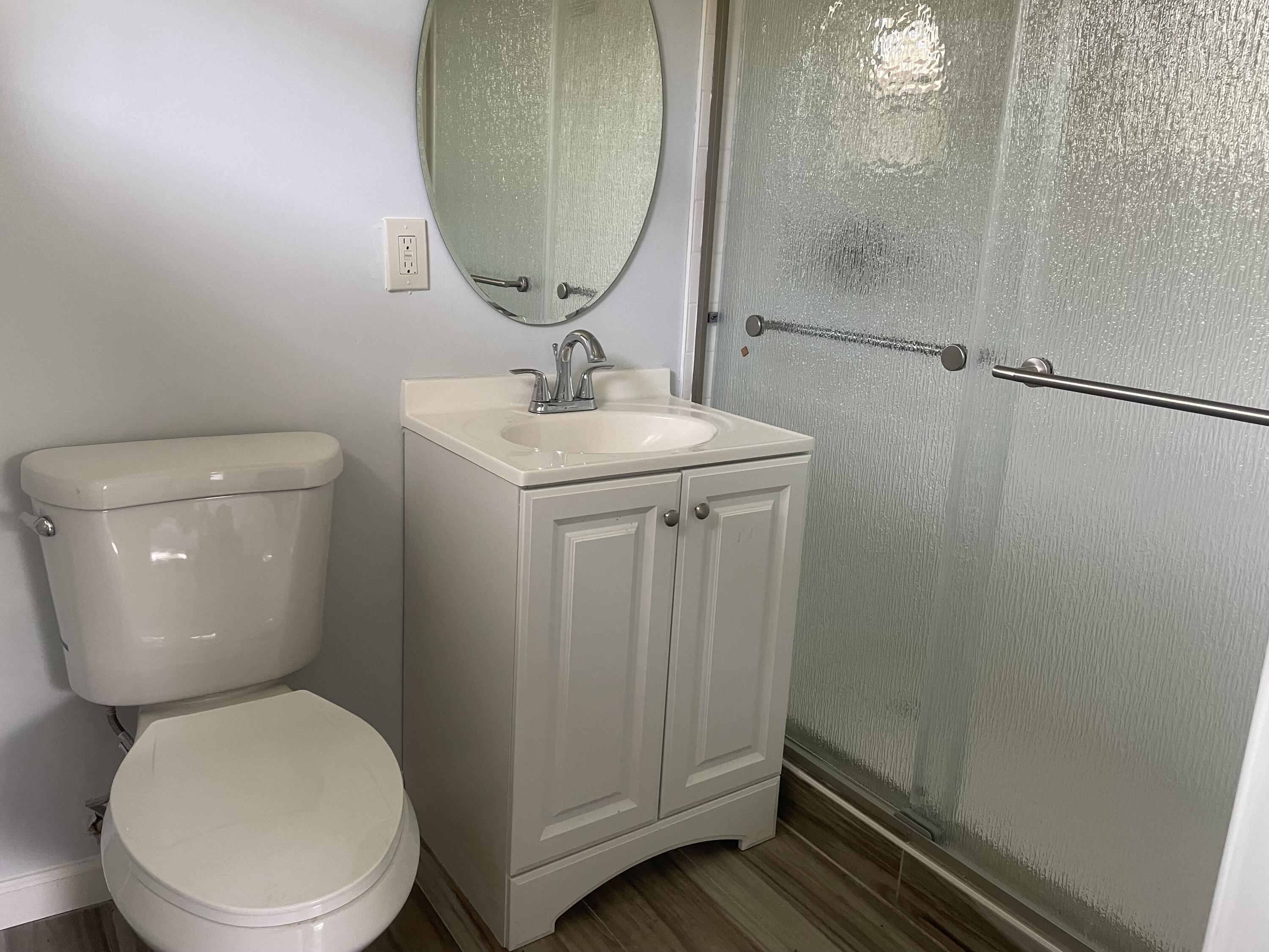 111 East 27th Street, Unit 113B Riviera Beach, FL 33404 - Photo 5 of 5 a bathroom with a toilet a sink and mirror