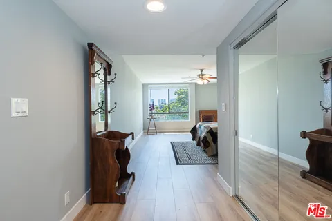 a spacious bedroom with a bed a dresser with wooden floor