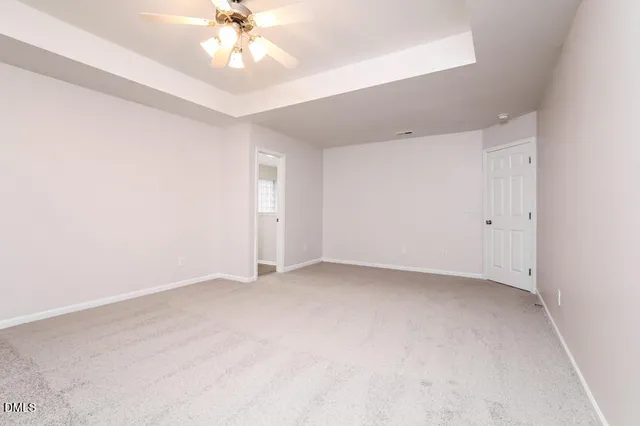 an empty room with a ceiling fan and a window