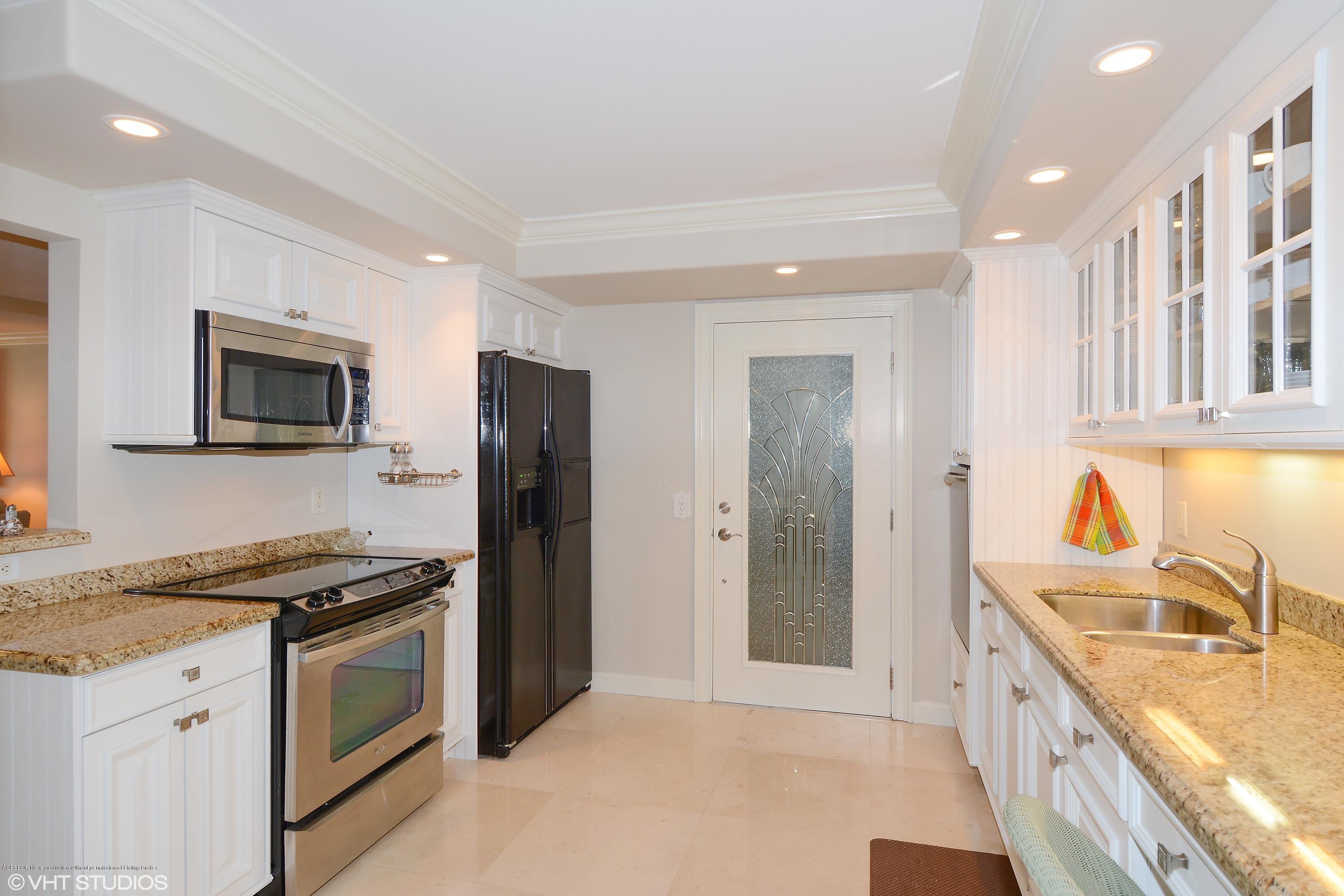 2190 Ibis Isle Road, Unit 1 Palm Beach, FL 33480 - Photo 3 of 8 a kitchen with stainless steel appliances granite countertop a stove a sink and a refrigerator