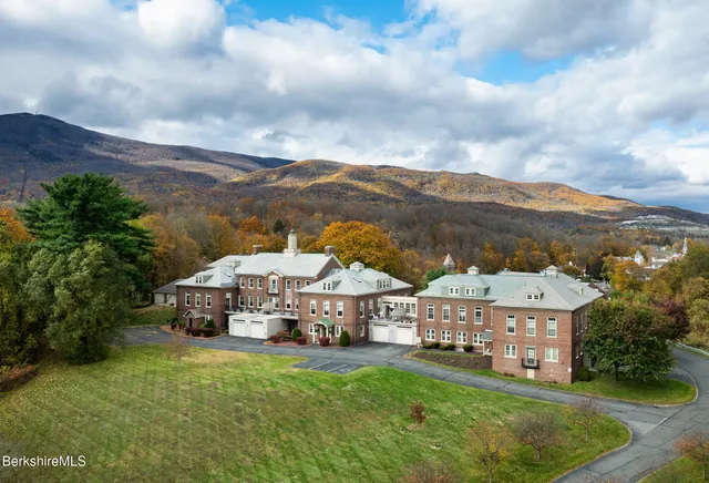 a aerial view of residential houses with yard and mountain view in front of house