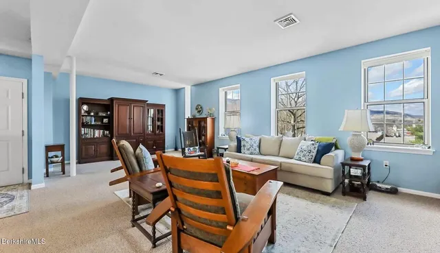 a living room with furniture a ceiling fan and a window
