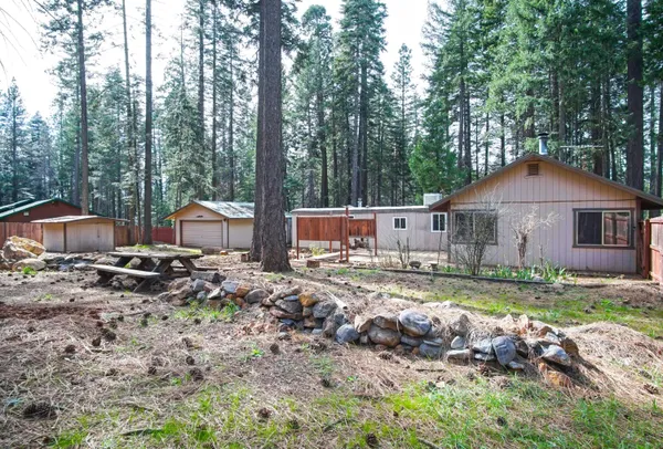 a backyard of a house with barbeque oven and outdoor seating
