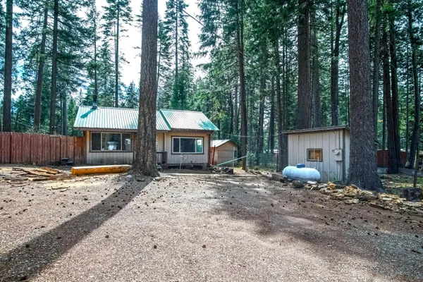 a front view of a house with a yard and wooden fence