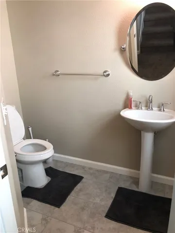 a view of a hallway with wooden floor and a bathroom