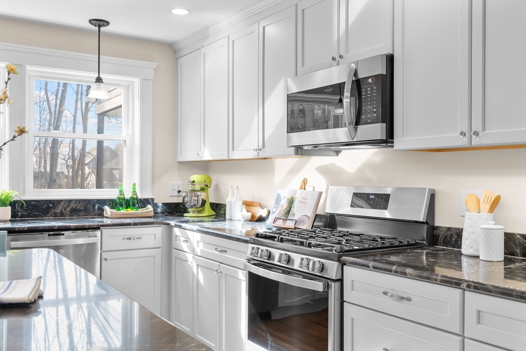 57 Edmund Road Arlington, MA 02474 - Photo 6 of 36 a kitchen with stainless steel appliances granite countertop a stove a sink and a microwave