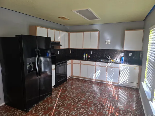a kitchen with granite countertop a refrigerator and a sink