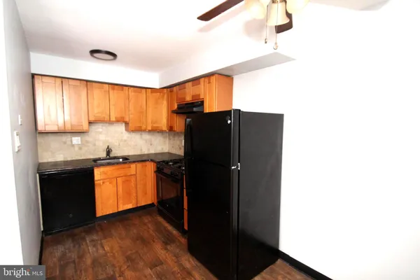 a kitchen with granite countertop a refrigerator and a sink