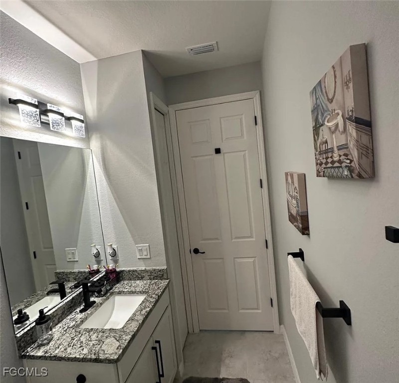 4117 Northwest 22nd Street Cape Coral, FL 33993 - Photo 17 of 31 a bathroom with a granite countertop sink a mirror and shower