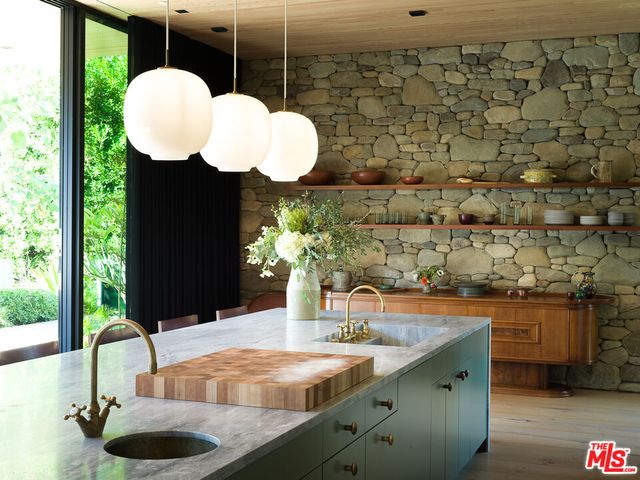 a view of a patio with couches plants and large trees