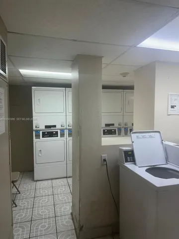 a room with a washing machine and a refrigerator