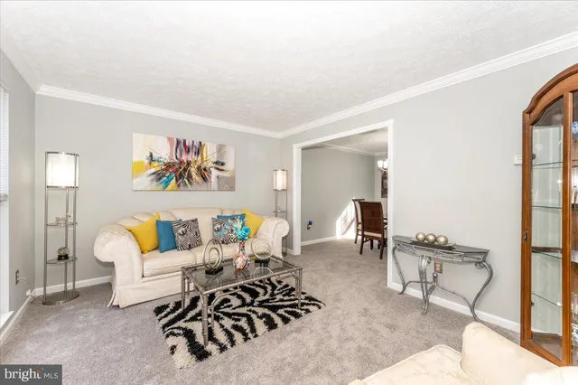 a living room with furniture and a large window with garden view