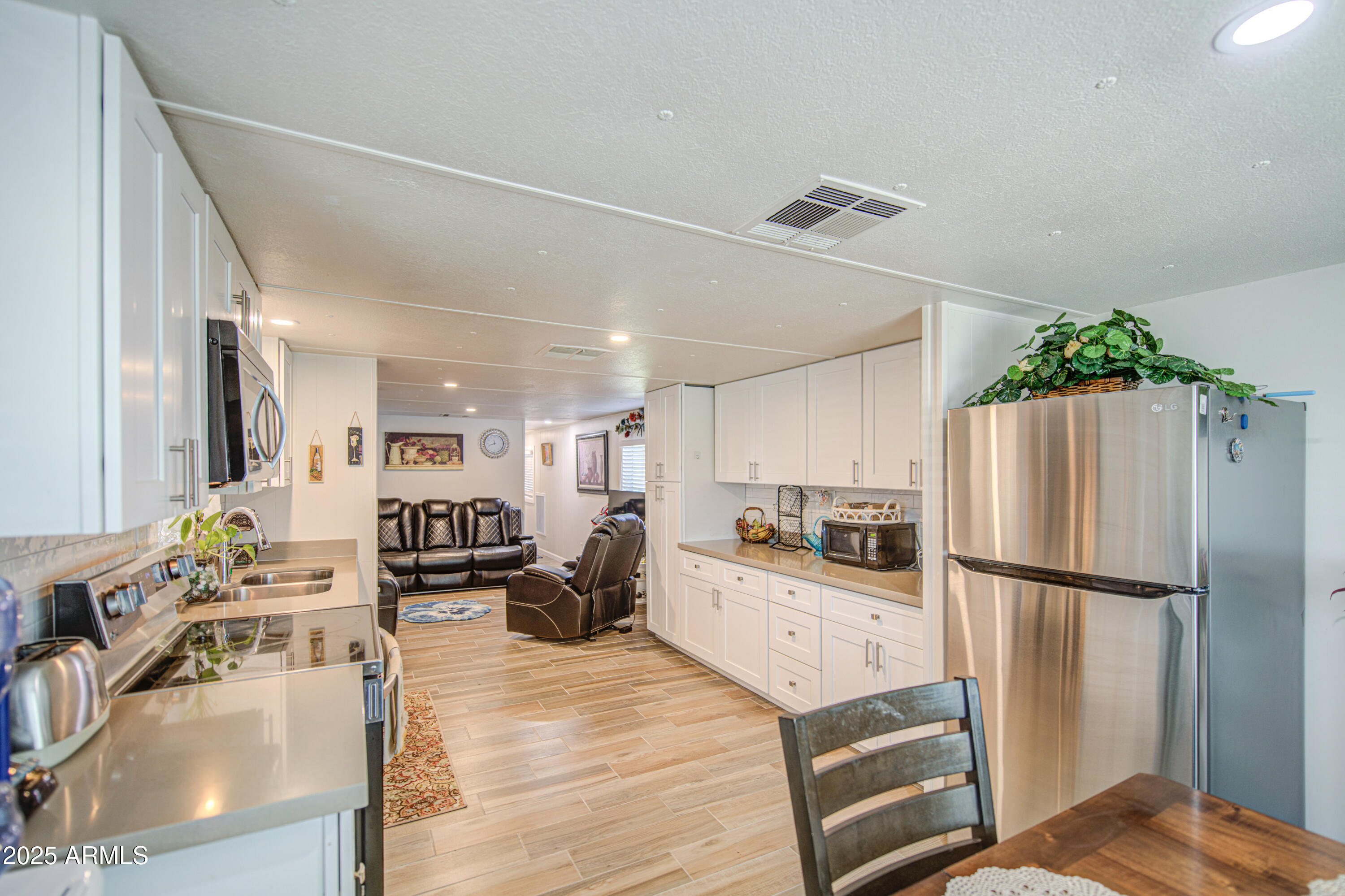 1304 East Bell Road, Unit 43 Phoenix, AZ 85022 - Photo 2 of 9 a kitchen with stainless steel appliances granite countertop a refrigerator a stove a sink dishwasher and a refrigerator with wooden floor