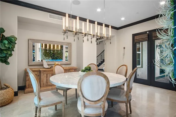 a view of a dining room with furniture a livingroom and chandelier