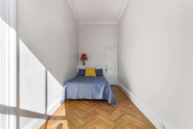 a bedroom with a bed and a potted plant