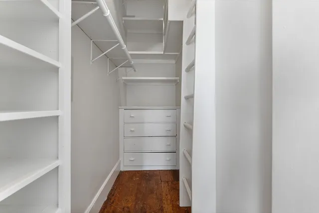 a view of walk in closet with empty racks