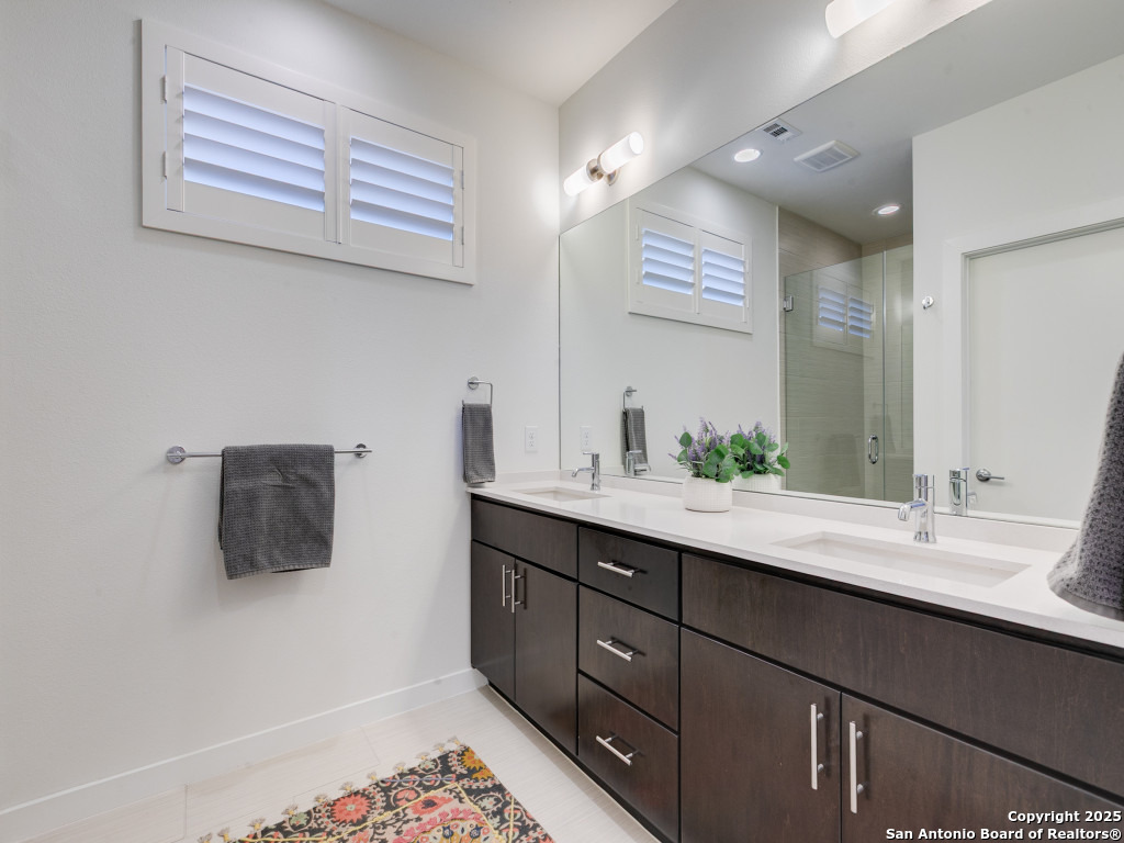 133 Terrell Road, Unit 1 Alamo Heights, TX 78209 - Photo 17 of 25 a bathroom with a sink double vanity and a mirror