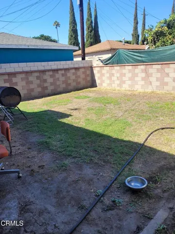 a view of a backyard with floor to ceiling window and potted plants