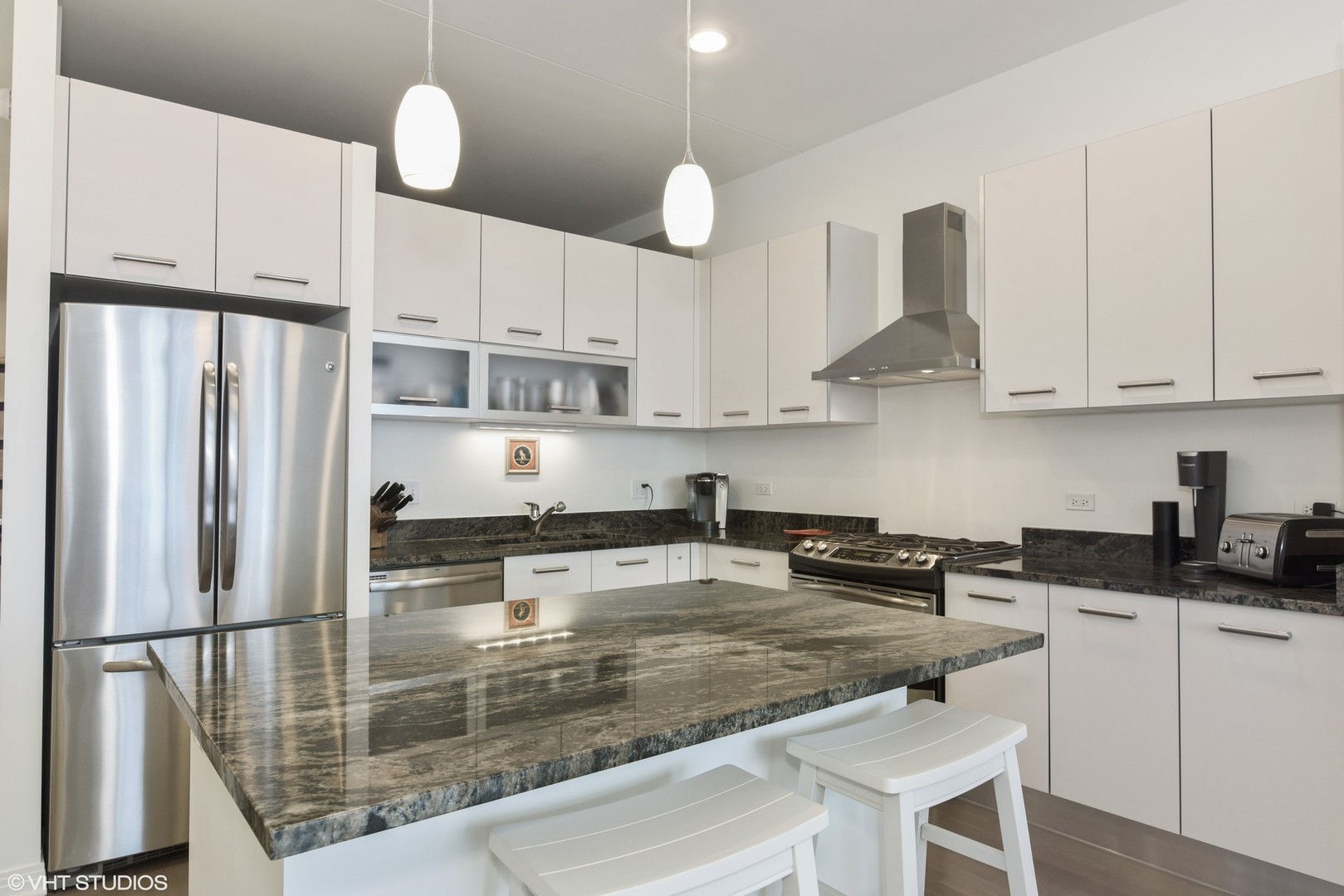 65 East Monroe Street, Unit 4015 Chicago, IL 60603 - Photo 5 of 14 a kitchen with stainless steel appliances granite countertop a refrigerator a sink a stove and white cabinets