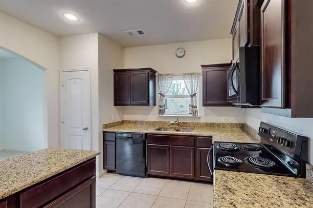 a kitchen with a sink stove and cabinets