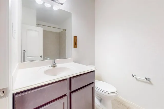a bathroom with a sink toilet and mirror