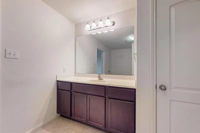 a bathroom with a granite countertop sink a large mirror and vanity
