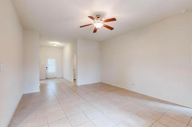 an empty room with fan and windows