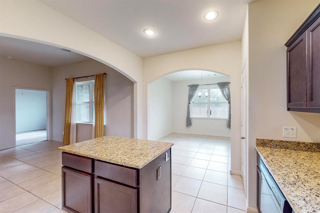 10 Kramer Court Sanger, TX 76266 - Photo 8 of 38 a kitchen with kitchen island granite countertop a sink and a stove
