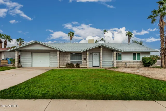 a front view of a house with a garden and yard