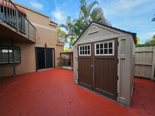 a view of a hallway with wooden cabinet and a kitchen