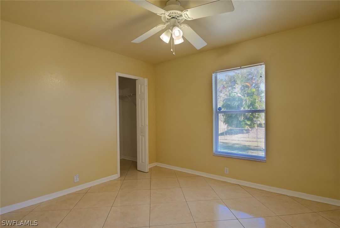 17525 Lee Road Fort Myers, FL 33967 - Photo 14 of 24 an empty room with a chandelier fan and windows