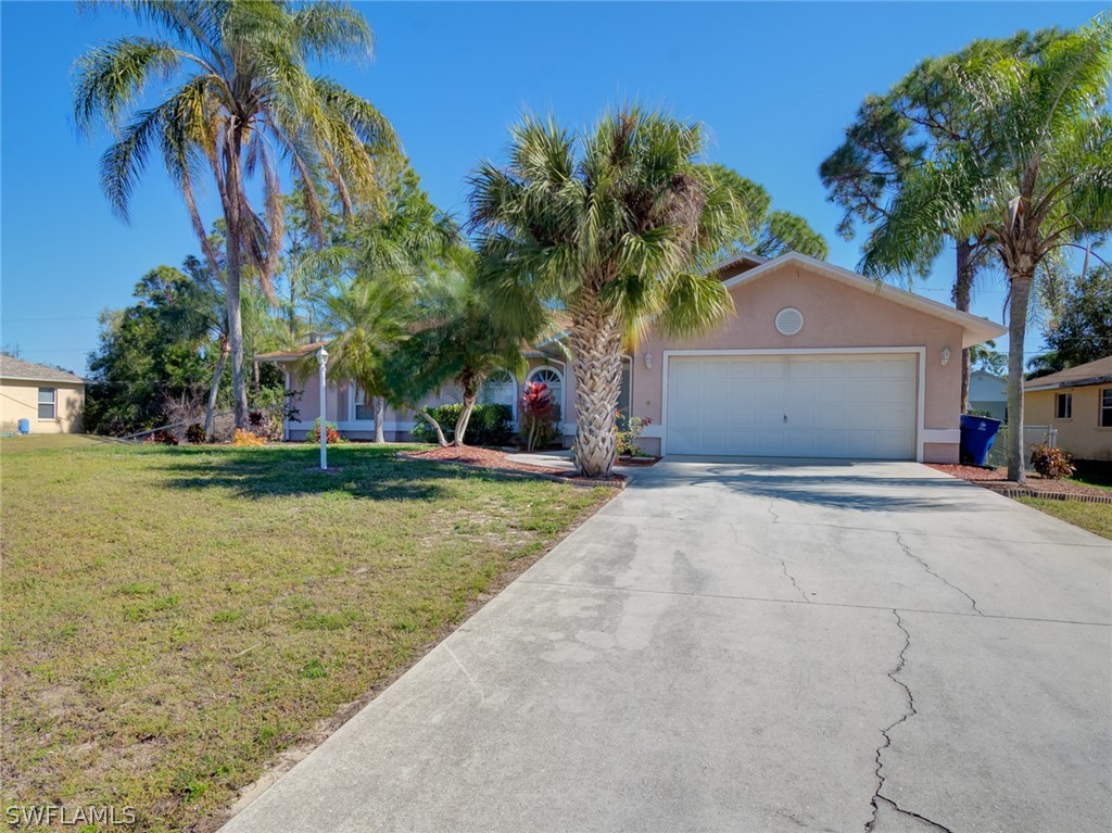 17525 Lee Road Fort Myers, FL 33967 - Photo 19 of 24 a front view of a house with a yard and a garage