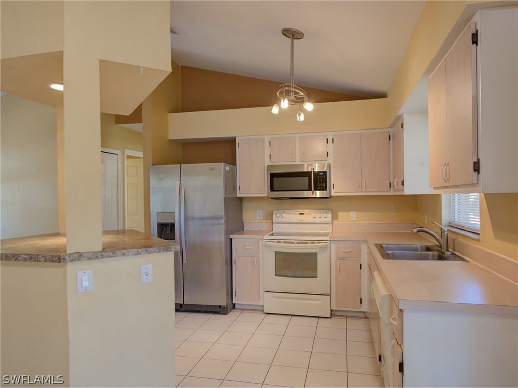 17525 Lee Road Fort Myers, FL 33967 - Photo 5 of 24 a kitchen with stainless steel appliances granite countertop a sink a stove a refrigerator and island with wooden floor