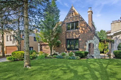 a front view of a house with a yard and trees