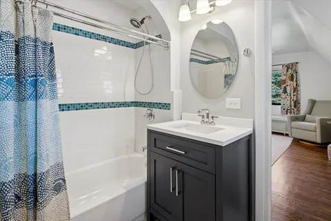 a bathroom with a bath tub sink and mirror