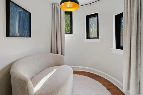 a living room with a bed and a painting on the wall