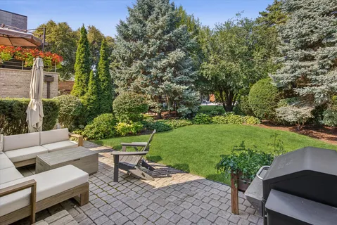 a view of a patio with couches table and chairs and potted plants