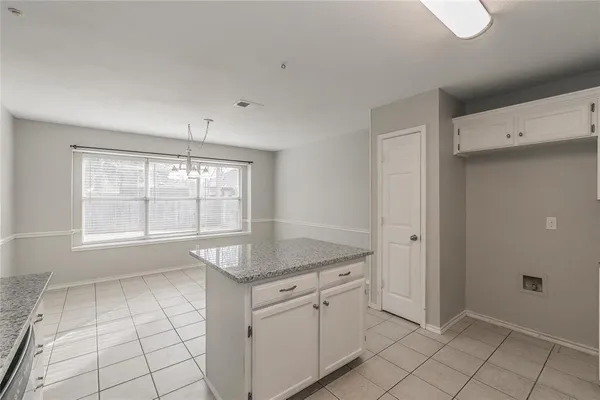 a kitchen with granite countertop white cabinets white appliances a sink and a large window