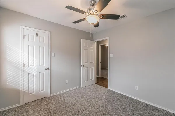 an empty room with a ceiling fan and a window