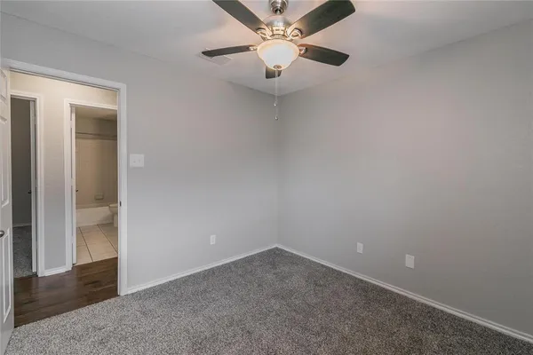 an empty room with a ceiling fan and a window