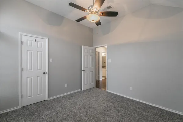 an empty room with closet and a chandelier fan