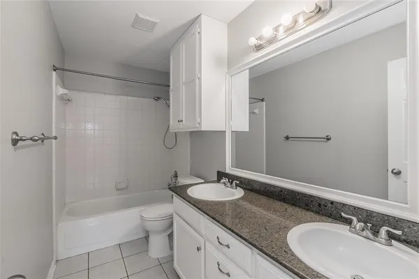 a bathroom with a granite countertop sink a toilet and shower