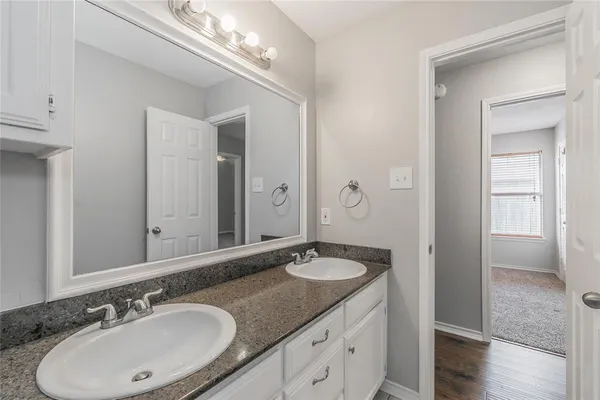 a bathroom with a double vanity sink and a mirror