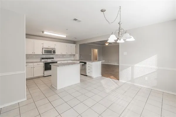 a kitchen with white cabinets and white appliances
