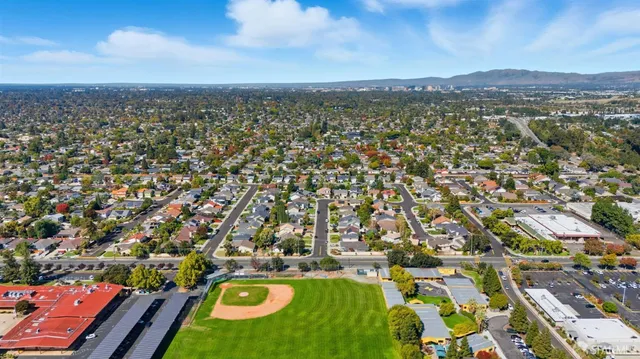 an aerial view of residential houses with outdoor space and swimming pool