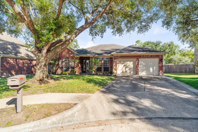 a front view of a house with a garden and trees